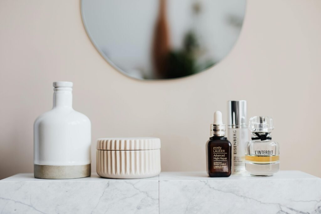 pexels-photo-4202329-4202329 Stylized skincare and cosmetic bottles on a marble shelf with mirror reflection.